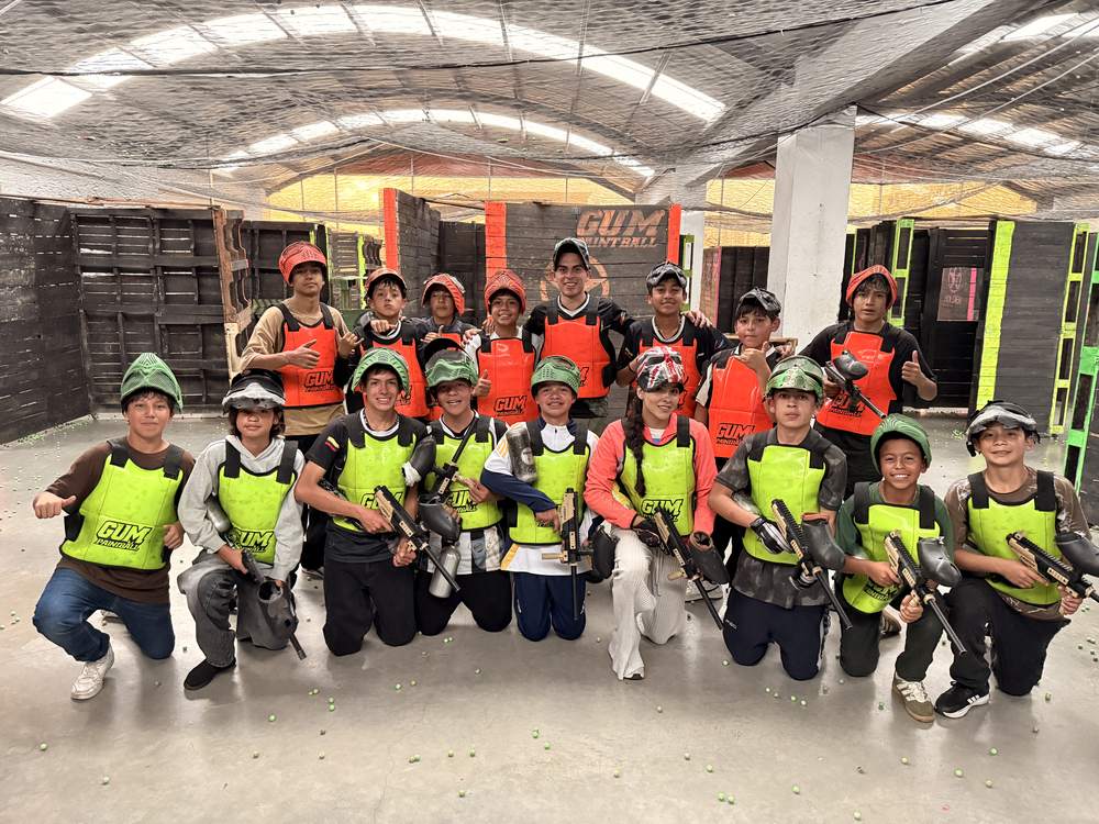 Grupo de jóvenes en el campo de paintball GUM Bogotá con chalecos y marcadoras